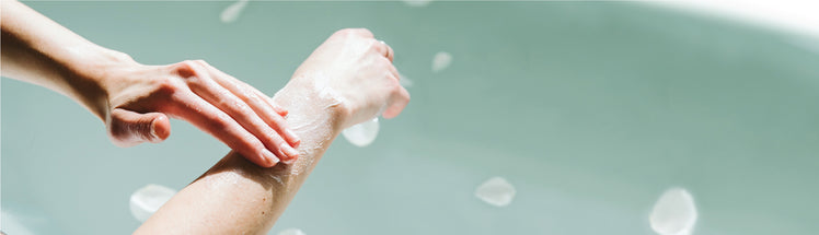 A person applying body oil onto their arm