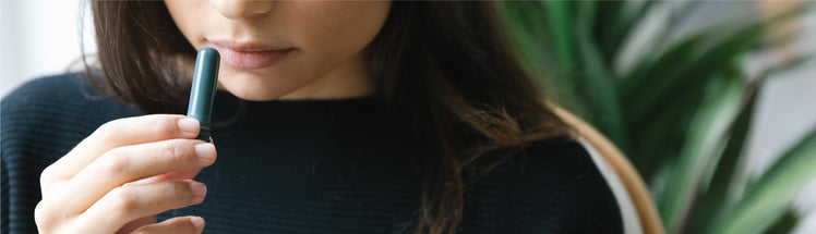 A woman using Saje inhaler to get a quick hit of wellness 