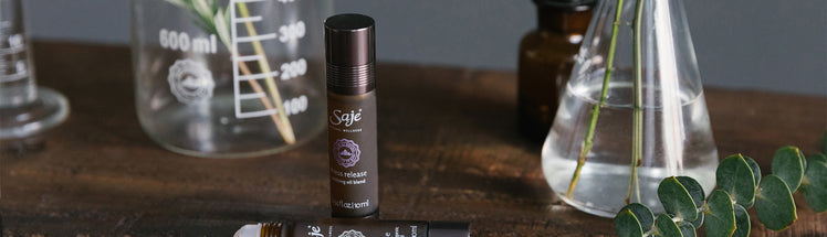 Stress release roll-on sitting on a wooden table next to glass beakers and eucalyptus