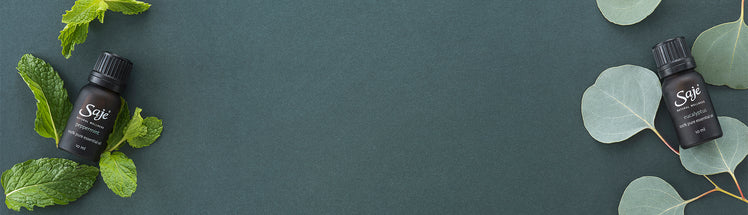 Saje diffuser blends and eucalyptus against a green background