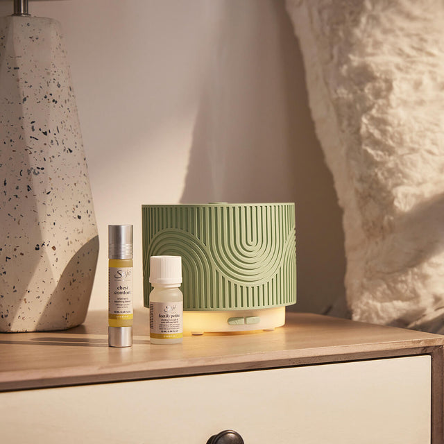 Aroma Nook pistachio sits on a dresser with Chest Comfort roll-on and Fortify Petite diffuser blend