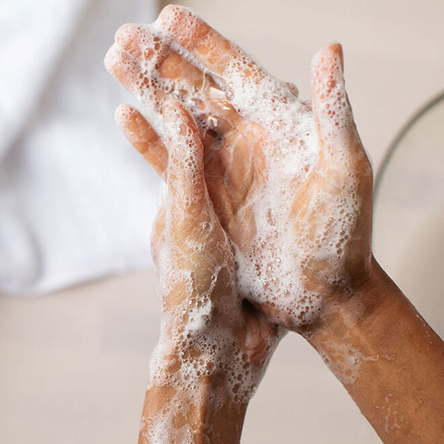 a pair of hands with bubbles from foaming hand soap